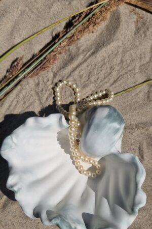 Lähivaade merekarbi-kujulisele alusele, näha on unikaalne mereroheline muster ja siidjas viimistlus.